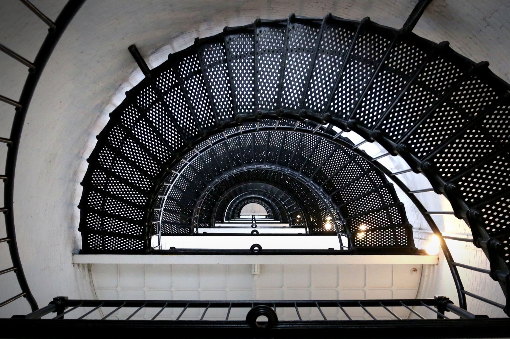A spiral staircase ascending toward the light